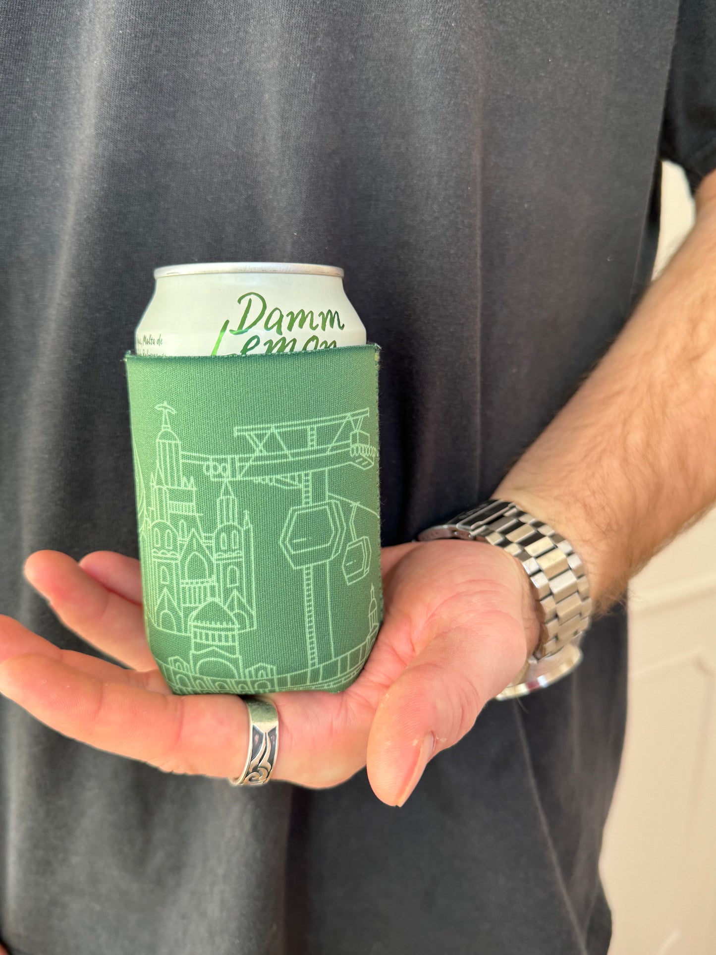 Man holding Tibidabo and Camp Nou line art souvenir on black neoprene koozie / killer koozys / stubby holder