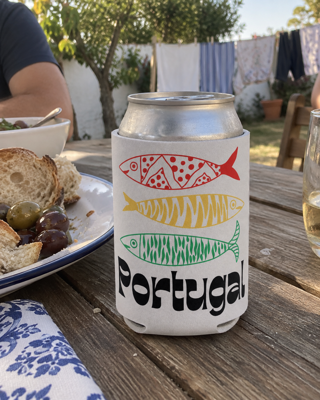 Portugal 3 Sardines White koozy on a wooden picnic table at a backyard lunch